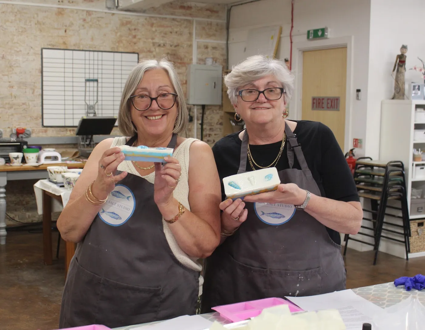 Two guests proudly holding their soaps